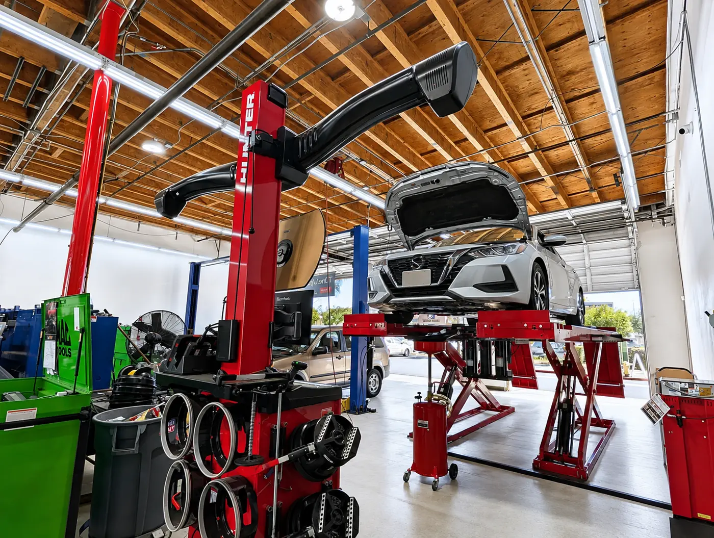 A Nissan sedan on the alignment lift at Super Service of Corona Hills