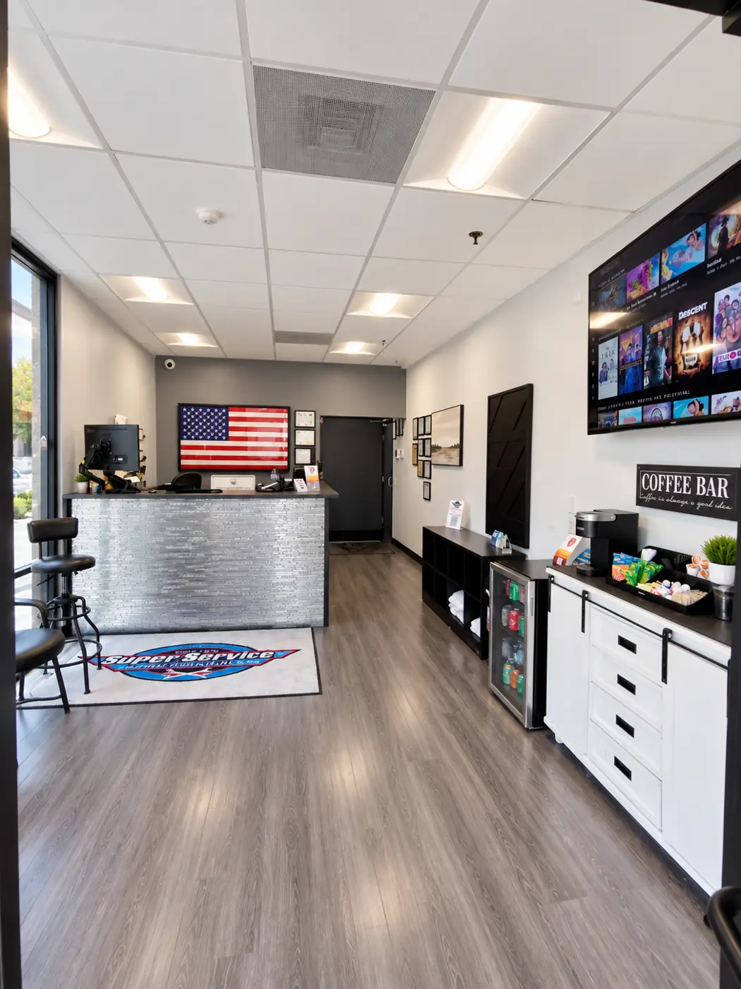Customer lounge with service counter, coffee bar, drink fridge, and TV